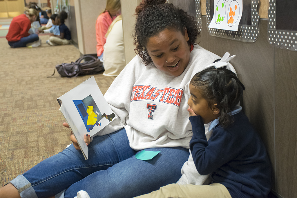 student teacher reading to young child