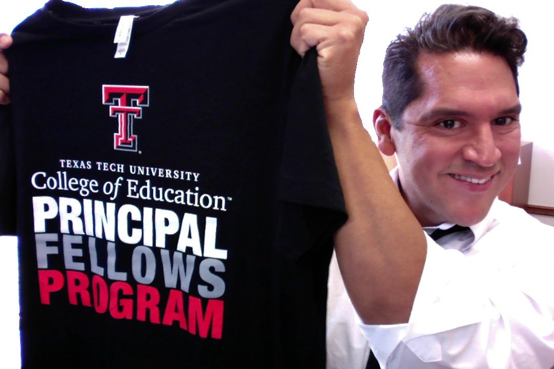 College of Education Dean Jesse Perez Mendez holding a Principal Fellows Program t-shirt
