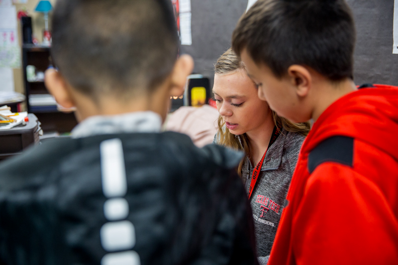 A teacher candidate working with students in a classroom