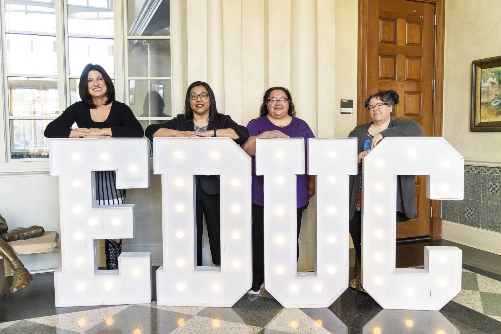 Grant team posing with giant letters EDUC