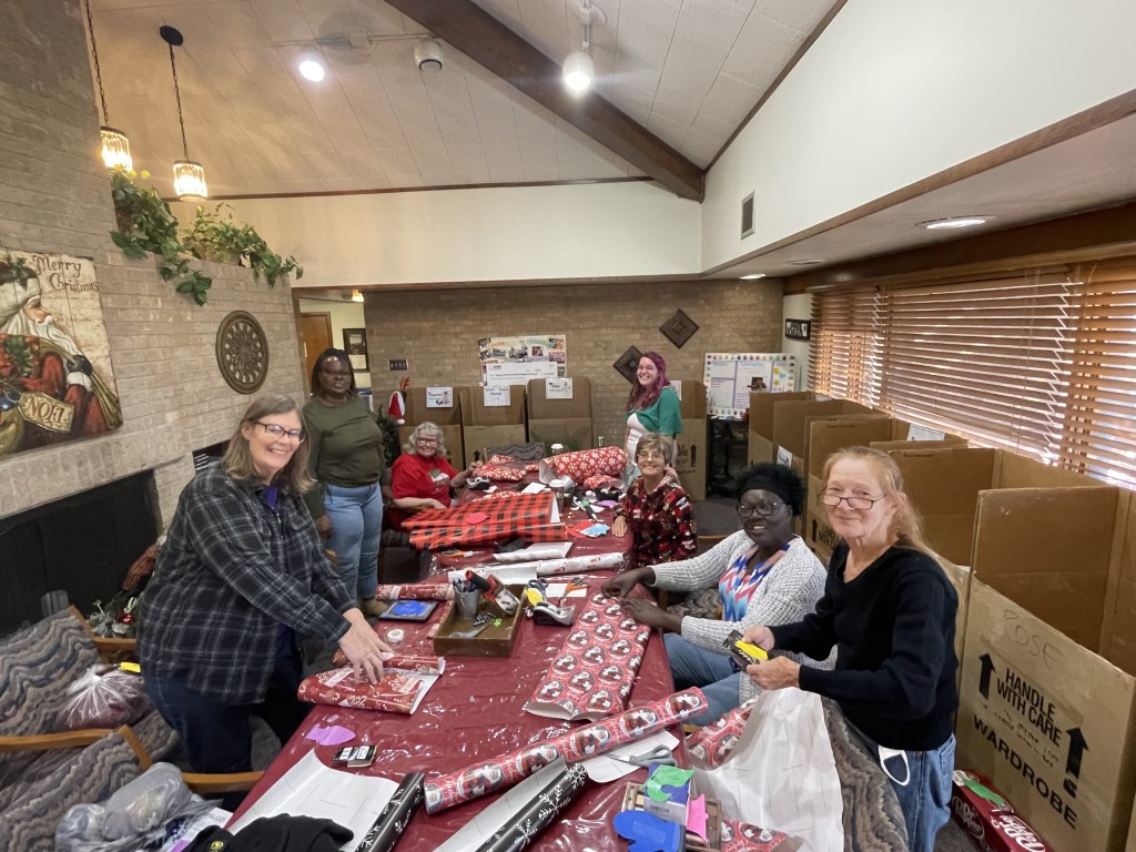 Members of the Sowell Center wrapping holiday presents at the Lubbock Supportive Living Center