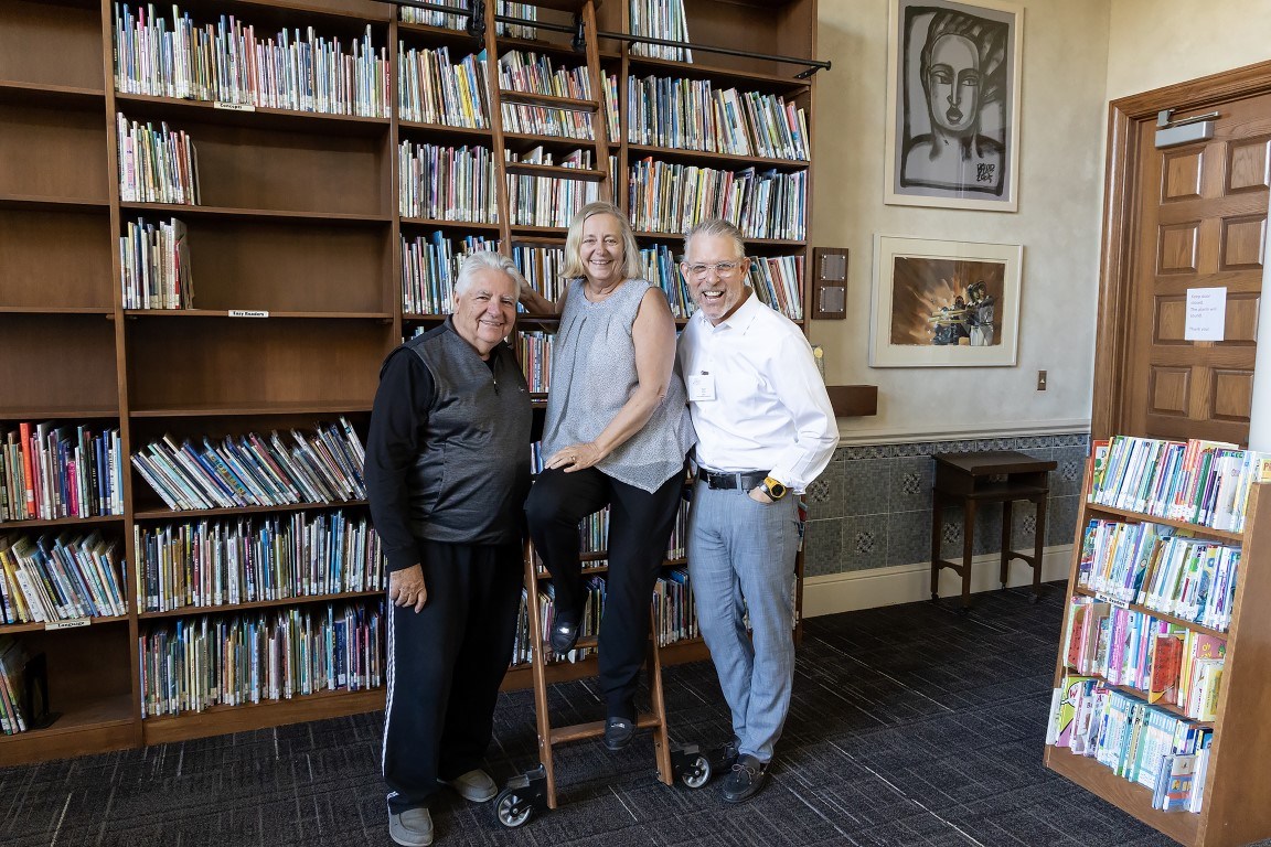 Trio posing on library ladder