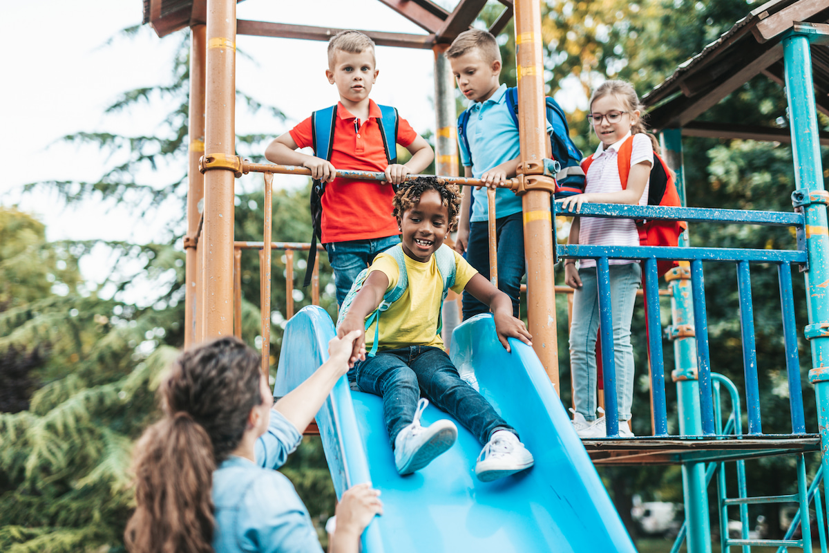 Teacher and elementary students on playground