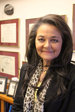 Headshot of Dr. Sutton with framed diplomas behind her.