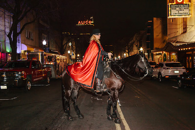 The Masked Rider and Fearless Champion cross a road in Downtown Waco at night