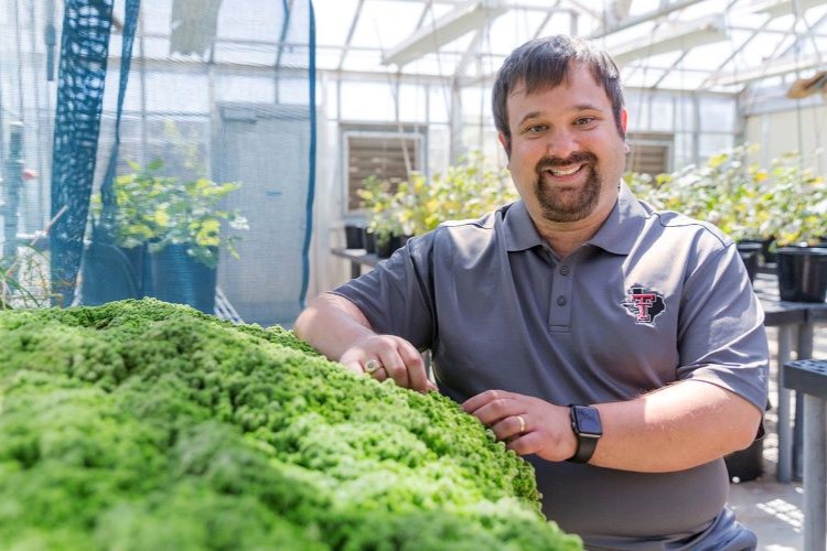 biologist-standing-near-elevated-plants-in-green-house