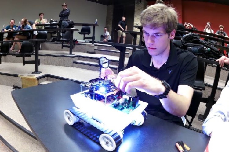 engineering-student-examining-his-illuminated-robot-tank