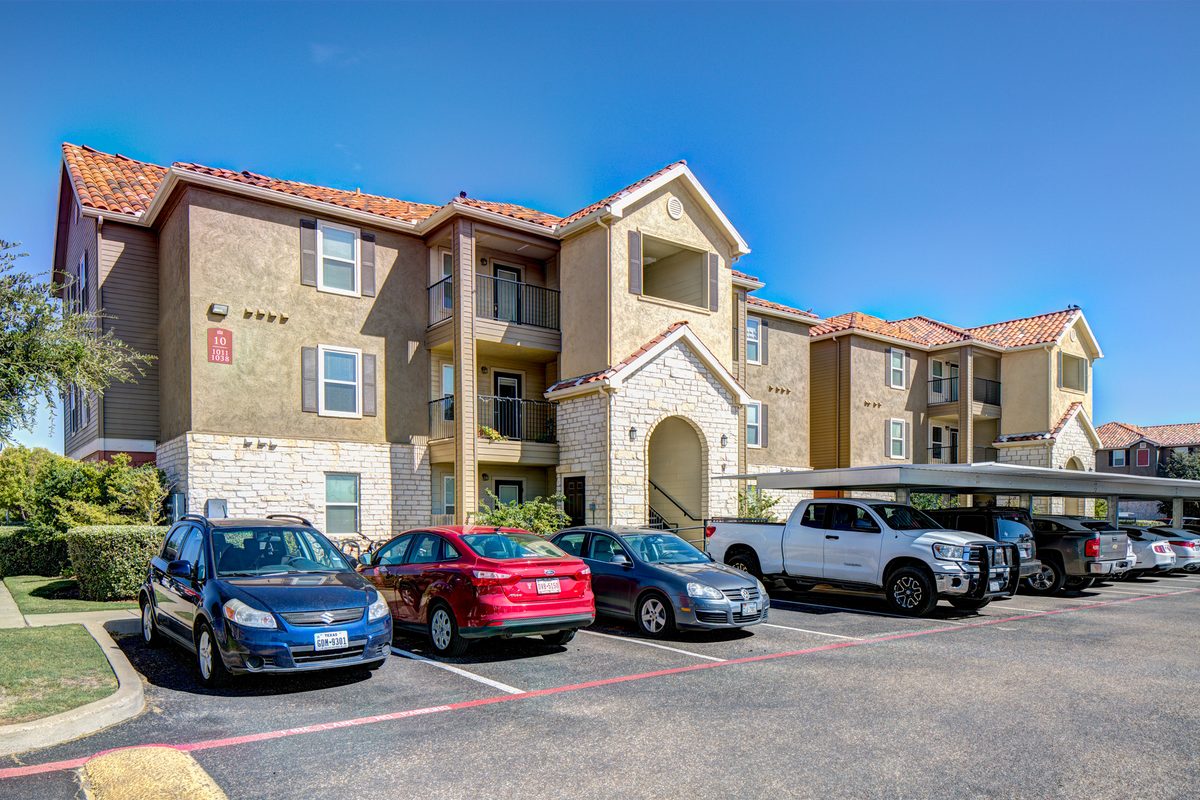 Exterior view of University Pointe student apartments with covered parking.