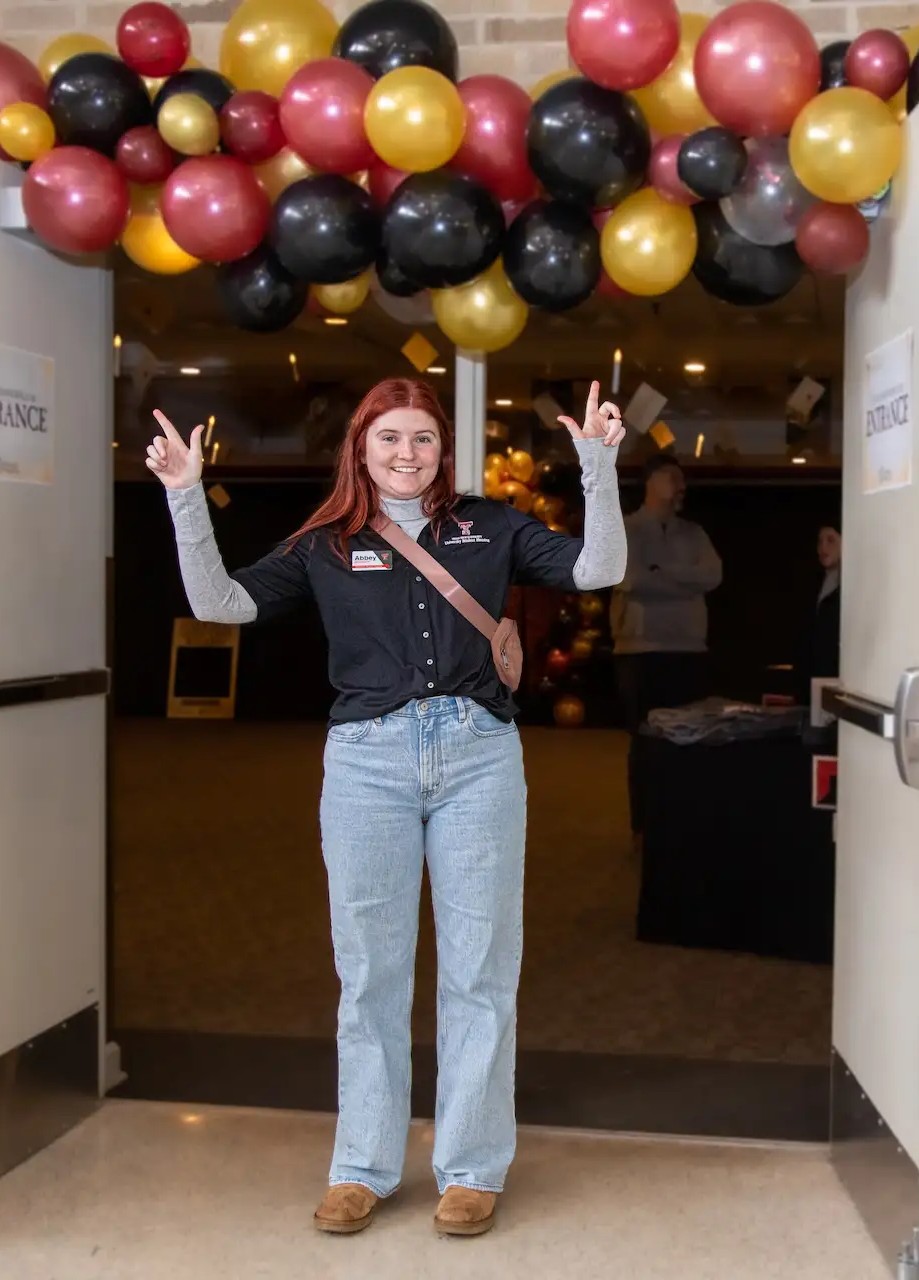 A person with gun's up standing in front of the housing fair