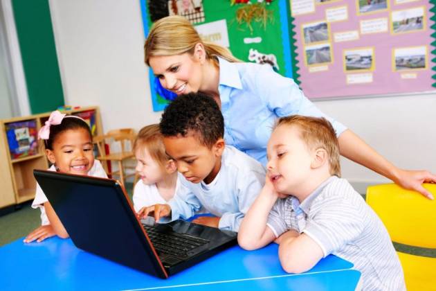 Teacher with children over a laptop