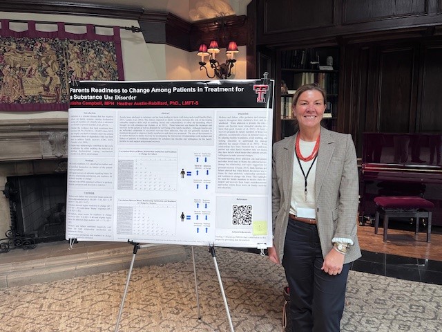 Alisha next to McKenzie Lectureship poster