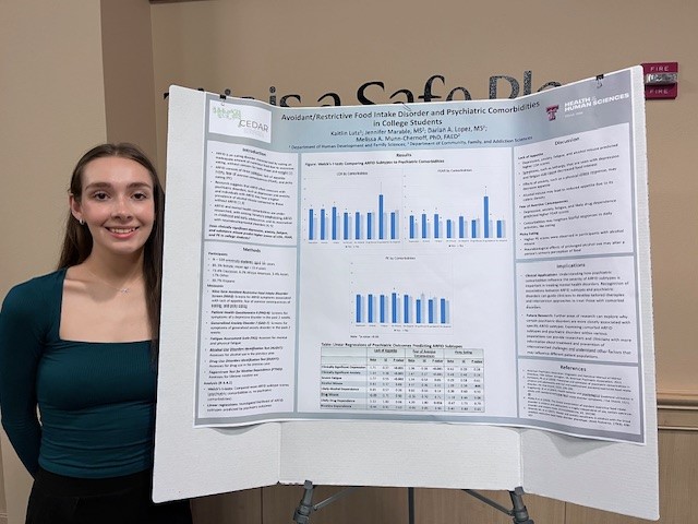 Kaitlin next to CFAS FIRE poster