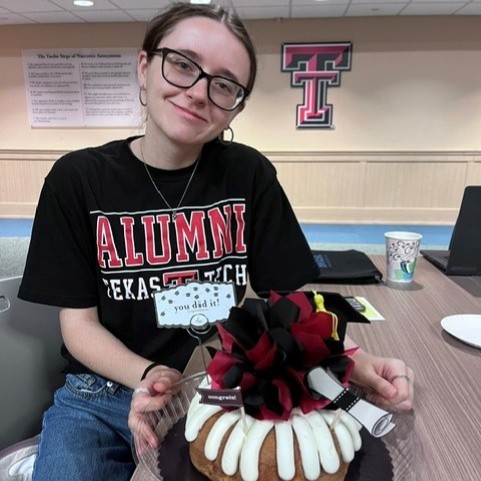 Trinity posing with graduation cake