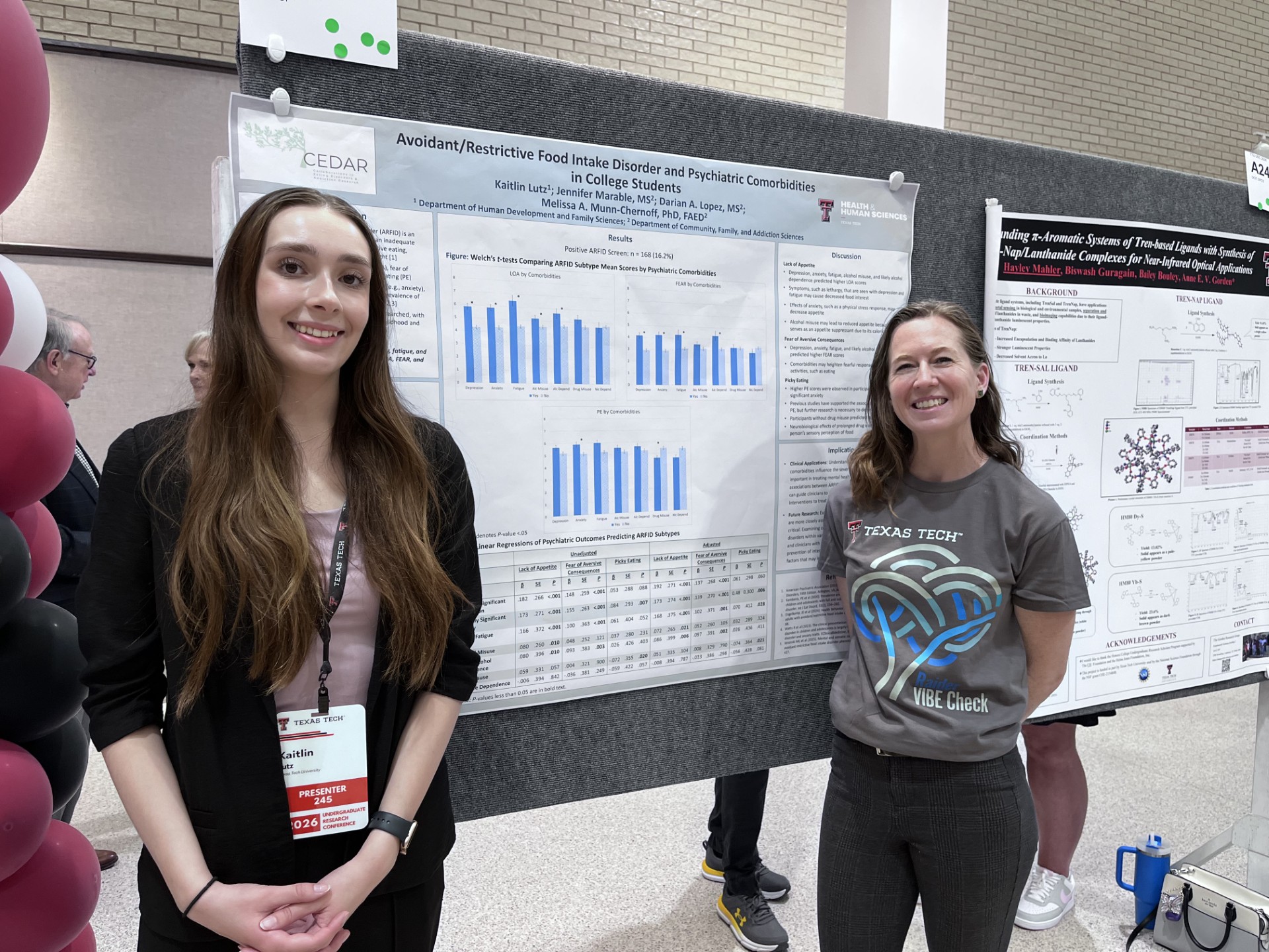 Kaitlin and Jen next to URC poster