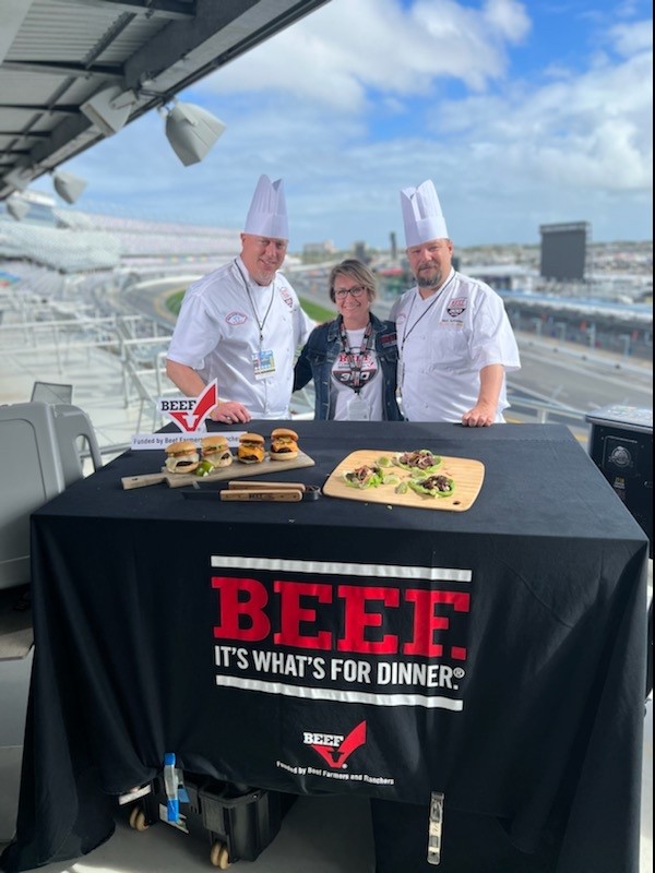 Mark Schneider (right) at "Beef. It's what's for dinner." stand in front of Daytona race track