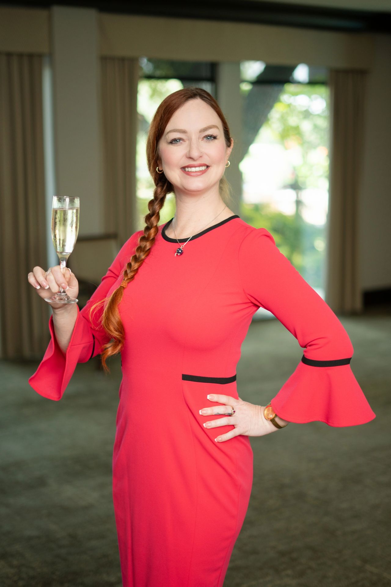 Tiffany Tobey in a red dress holding a glass of wine