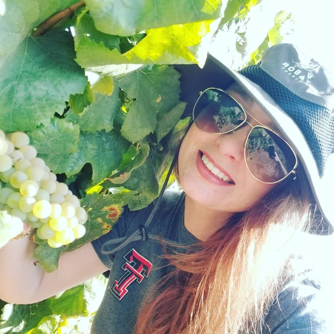Tiffany Tobey in a vineyard wearing a Texas Tech shirt