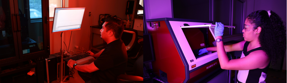 students sitting and standing in front of machinery looking at the machine and screens