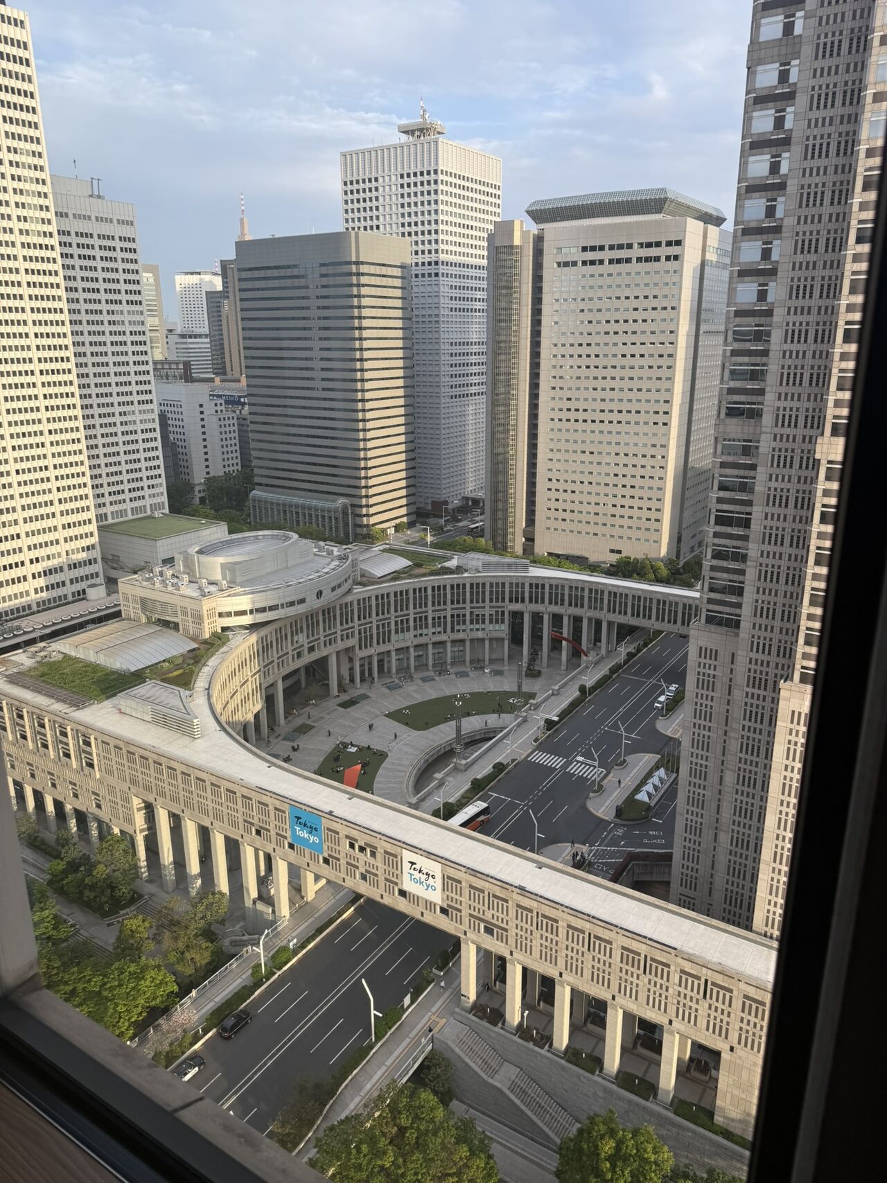 View outside the window of a hotel showcasing large skyscrapers in a Japanese city.