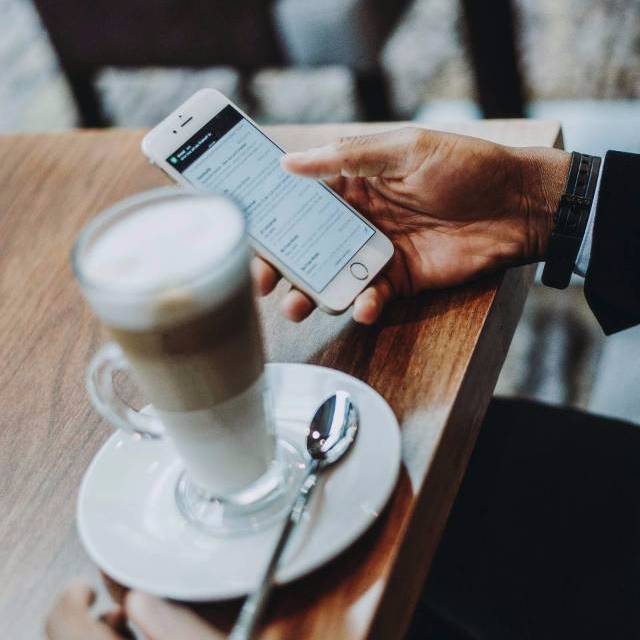Person getting coffee using a smart phone.