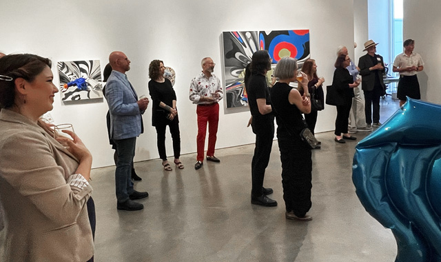 Multiple people at an art gallery exhibit