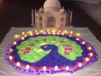 K-12 students place flower petals on a traditional Rangoli design for Diwali during the Celebration of Light. 