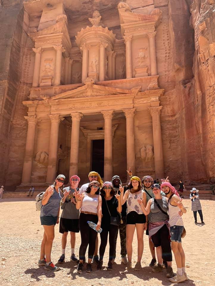 Group standing in front of carvings in Jordan.