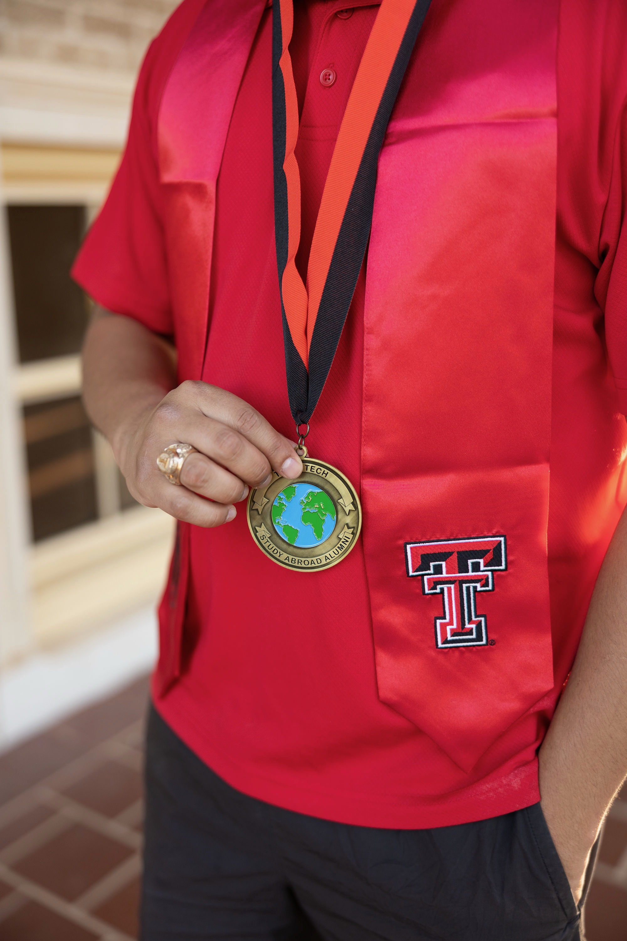 Male student wearing study abroad medal with graduation regalia