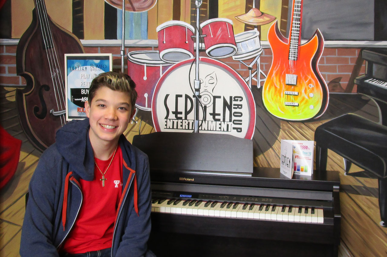 Austin Chatfield posing in the lobby of his second home, Septien Entertainment Group.