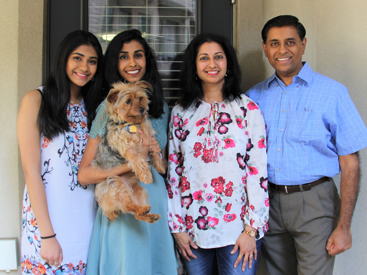 Mohana (left) with older sister Sahana and family pet Max; mother Saipriya and father Manjeri Krishnan.