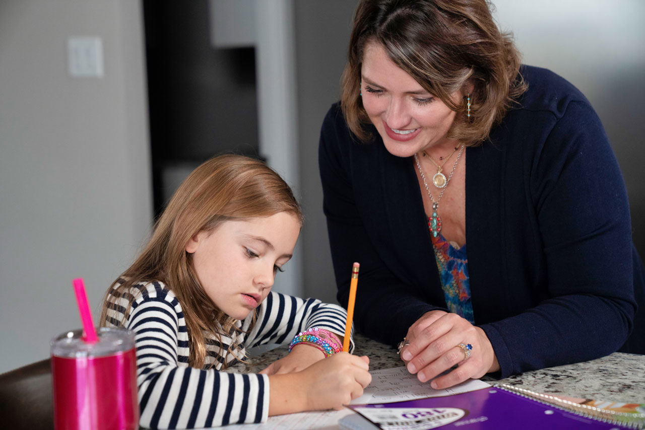 Tenlee Nyman getting help with her schoolwork from her mom.