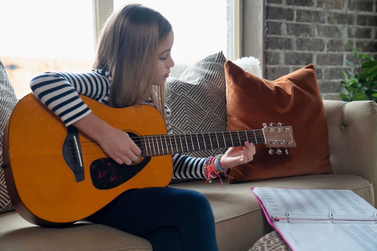 Tenlee Nyman practicing guitar.