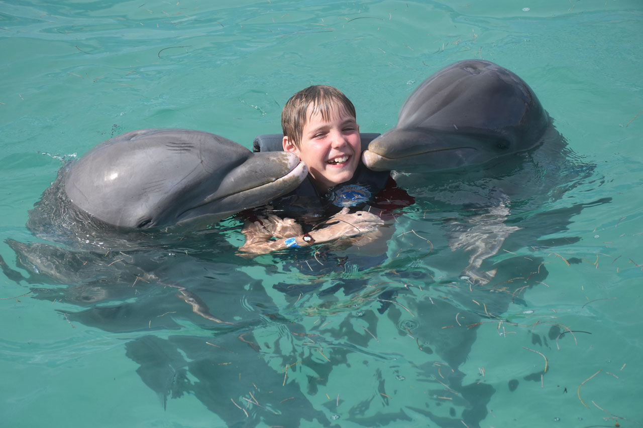Travis swimming with dolphins on a family trip to the Dominican Republic.