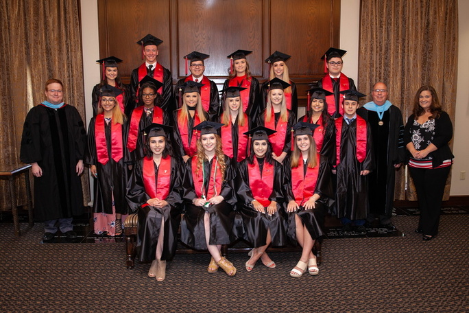 Representative of the 2018 TTU K-12 graduates stand in center frame with four students standing and thirteen students standing between Justin Louder and Jim Taliaferro and Cari Moye