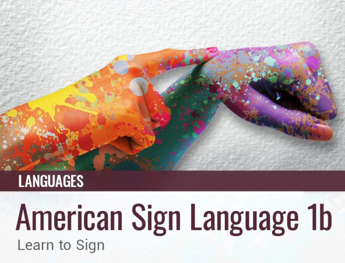 A pair of hands that are splotched yellow, orange, green, purple and teal while depicting a sign language sign