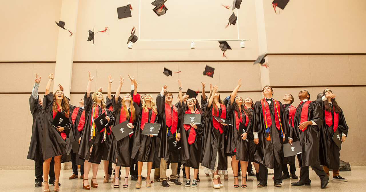 TTU K-12 graduates toss their graduation caps into the air.