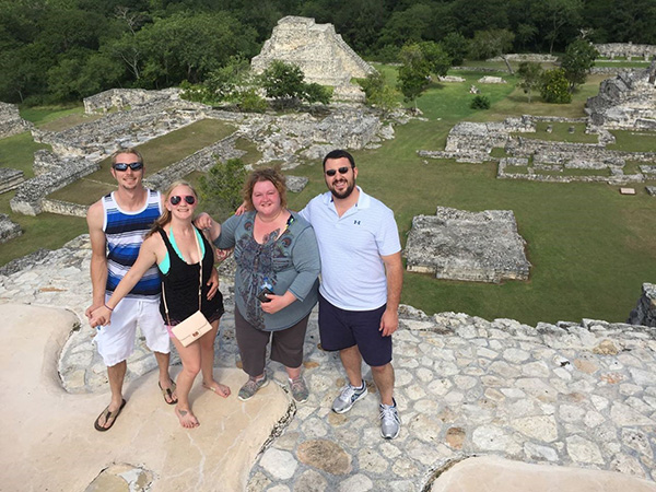 Crystal, vacationing with friends, at the Mayapan Ruins in Yucatan, Mexico. Crystal Green stands alongside three friends on Mayapan Ruins looking upwards