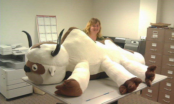 Crystal poses with a custom-ordered stuffed piece she created. Crystal Green stands in an office behind a large plush animal