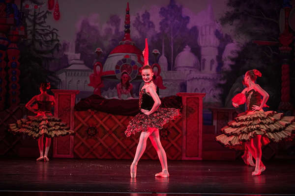 Emma Gray strikes a pose at stage alongside three other dancers