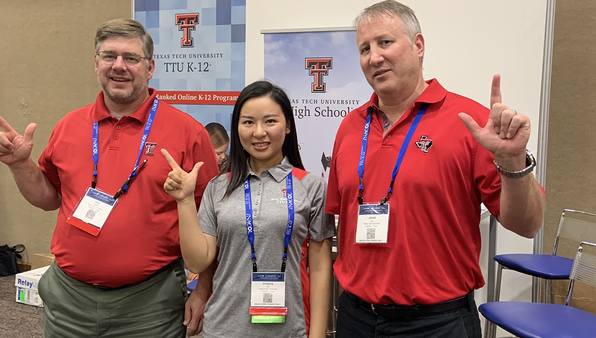 Cary Sallee, Victoria Qin and Jared Lay giving the guns up sign in front of the TTU K-12 booth at the iNACOL conference in October.