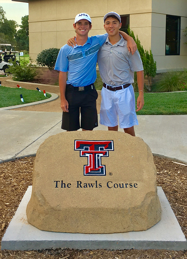 Mikey and Zach stand closely together as both place one arm over the others shoulder and stand behind a large manufactured stone with the TTU logo and the words "The Rawls Course"
