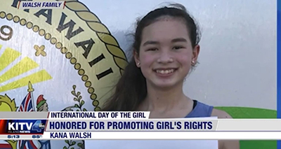 A young woman smiles as she stands center frame with a caption at the bottom of the photo that reads honored for promoting girl's rights