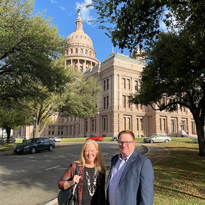 Lisa Leach and Justin Louder in front of the Texas state capitol building.