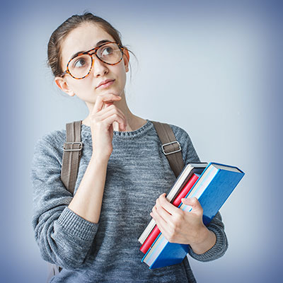 Student with books rubs chin in thought.