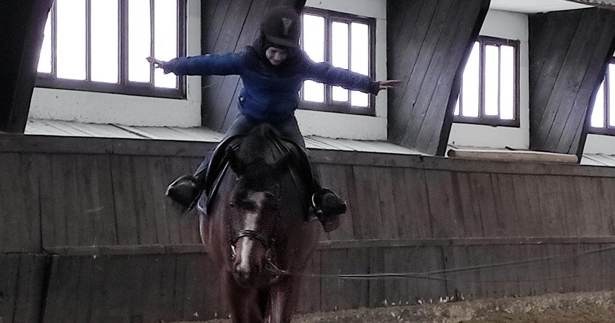 Marcel Łękawski riding a horse in a riding stable.