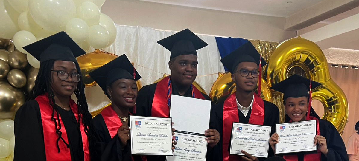 Graduates pose with diplomas