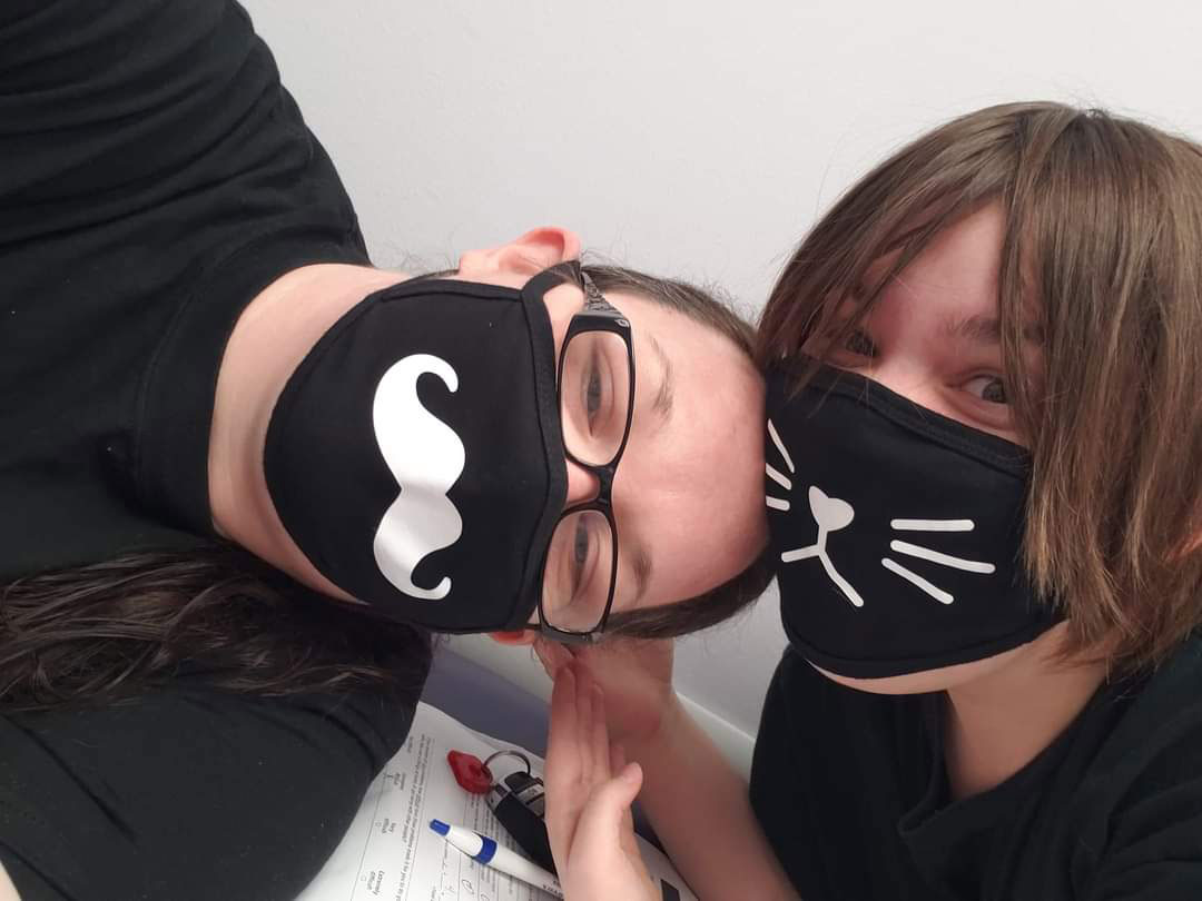 Candace in a mustace face mask and Makayla in a cat face mask