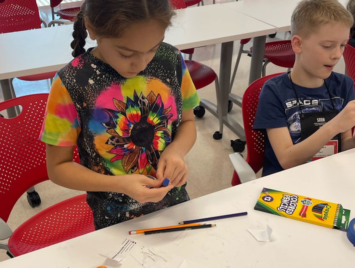 Rilynn and Nicholas engineering paper rockets.