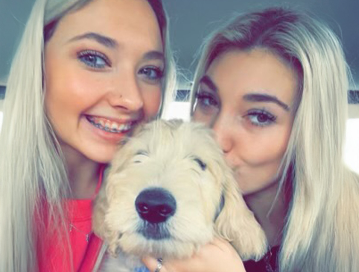 Torri's golden doodle, Kenny, is her constant companion (pictured with sister Ashley)