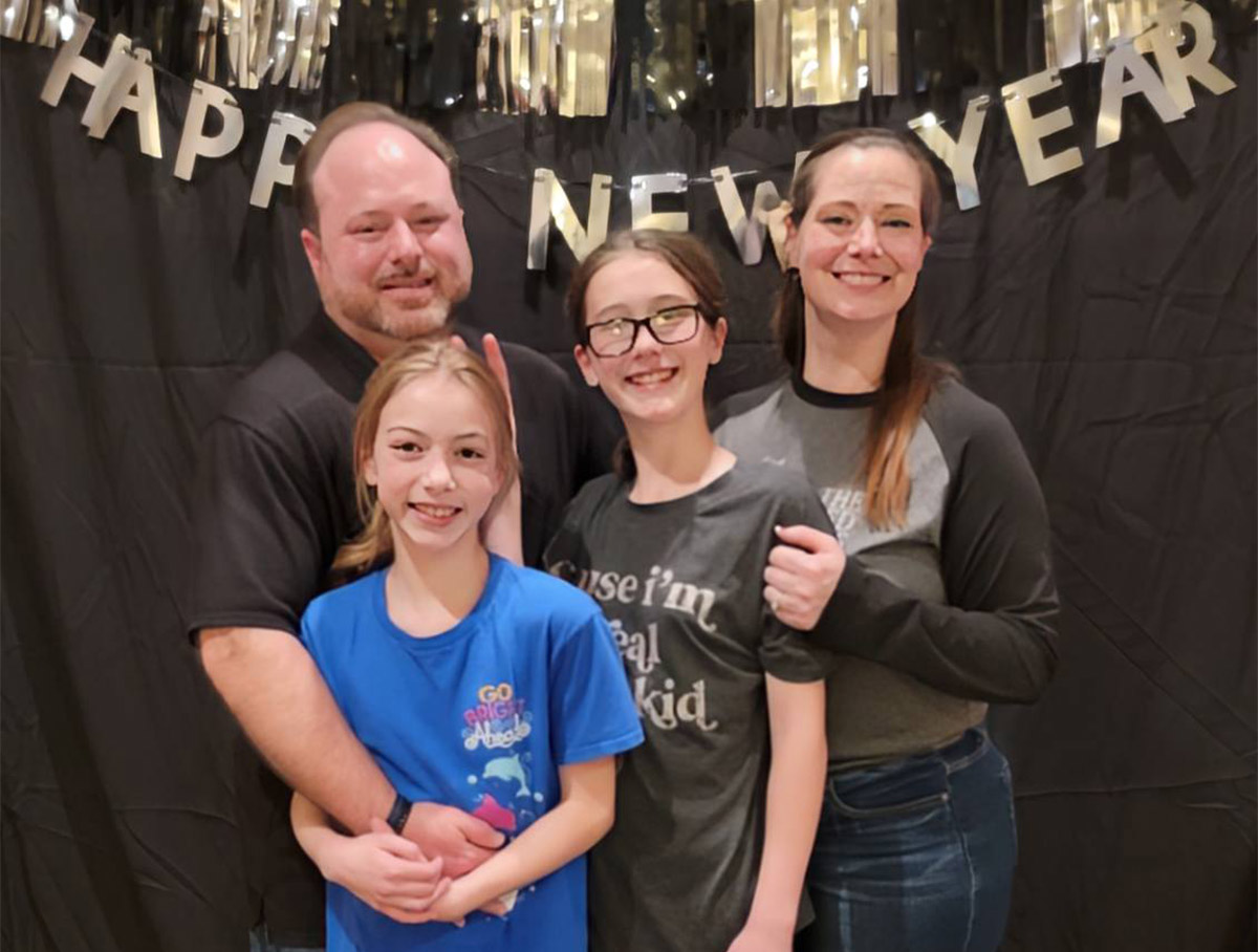 James Theresa Evie Katie New Years Eve 2024.jpeg (Caption: Evie (front) with dad Jason, sister Katie and mom Theresa)